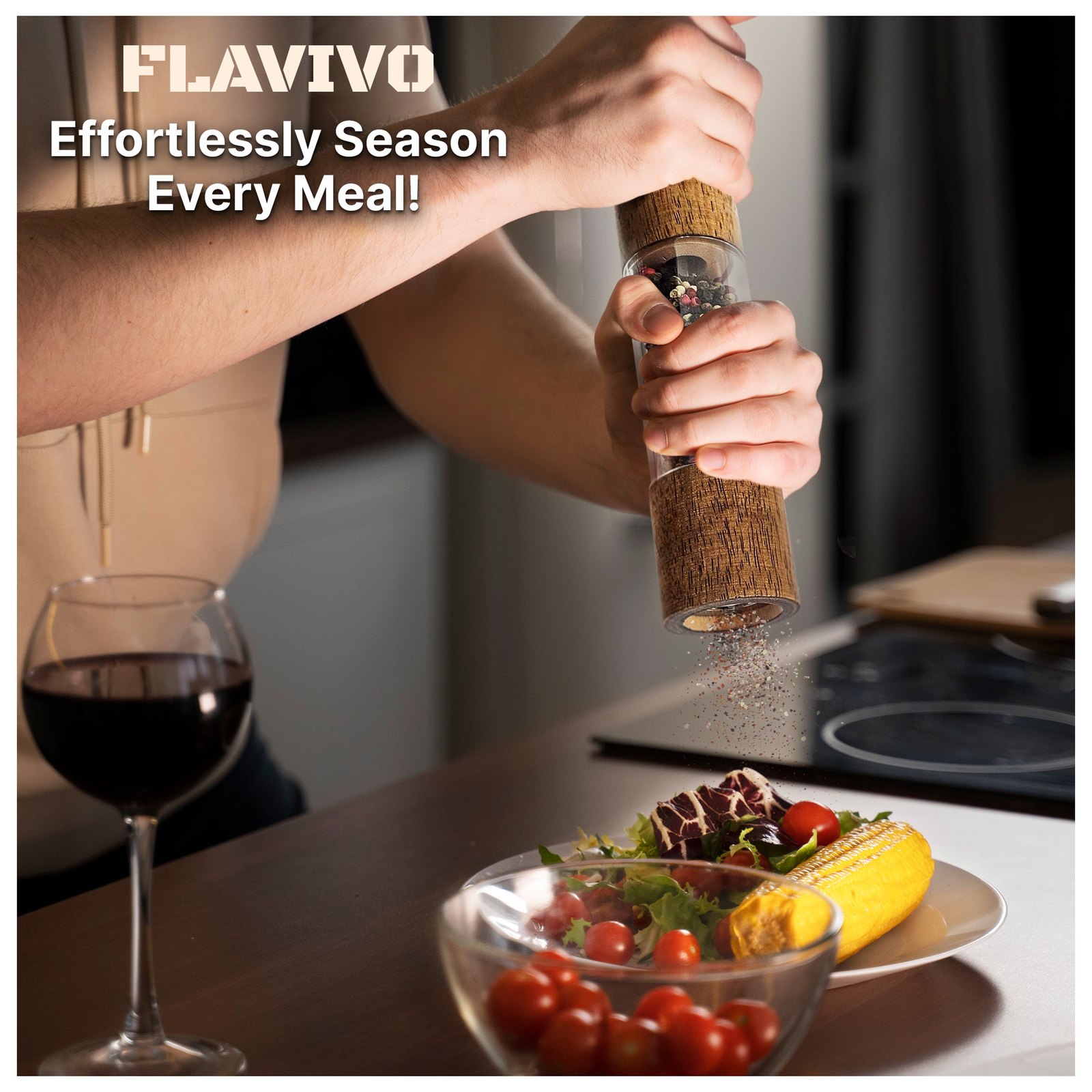 Man grinding pepper over a salad with a glass of red wine