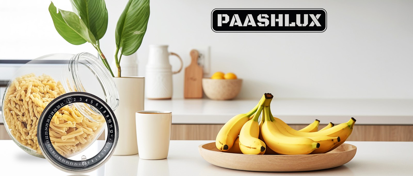 PAASHLUX brand banner with a glass tilted jar of pasta, a bowl of bananas and the black PAASHLUX wordmark on a kitchen counter
