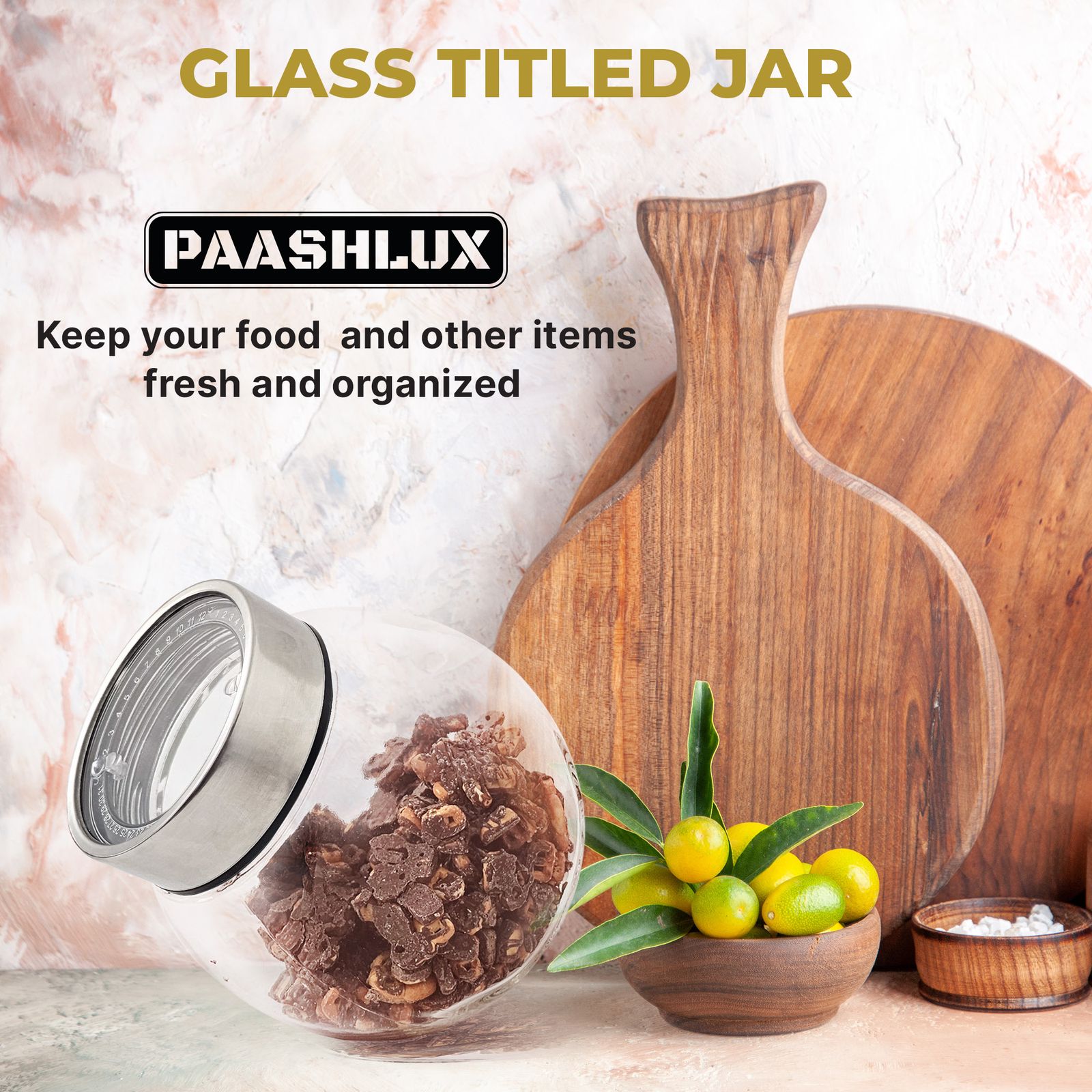 Glass tilted jar with dried snacks on a kitchen counter beside a wooden board and lemons