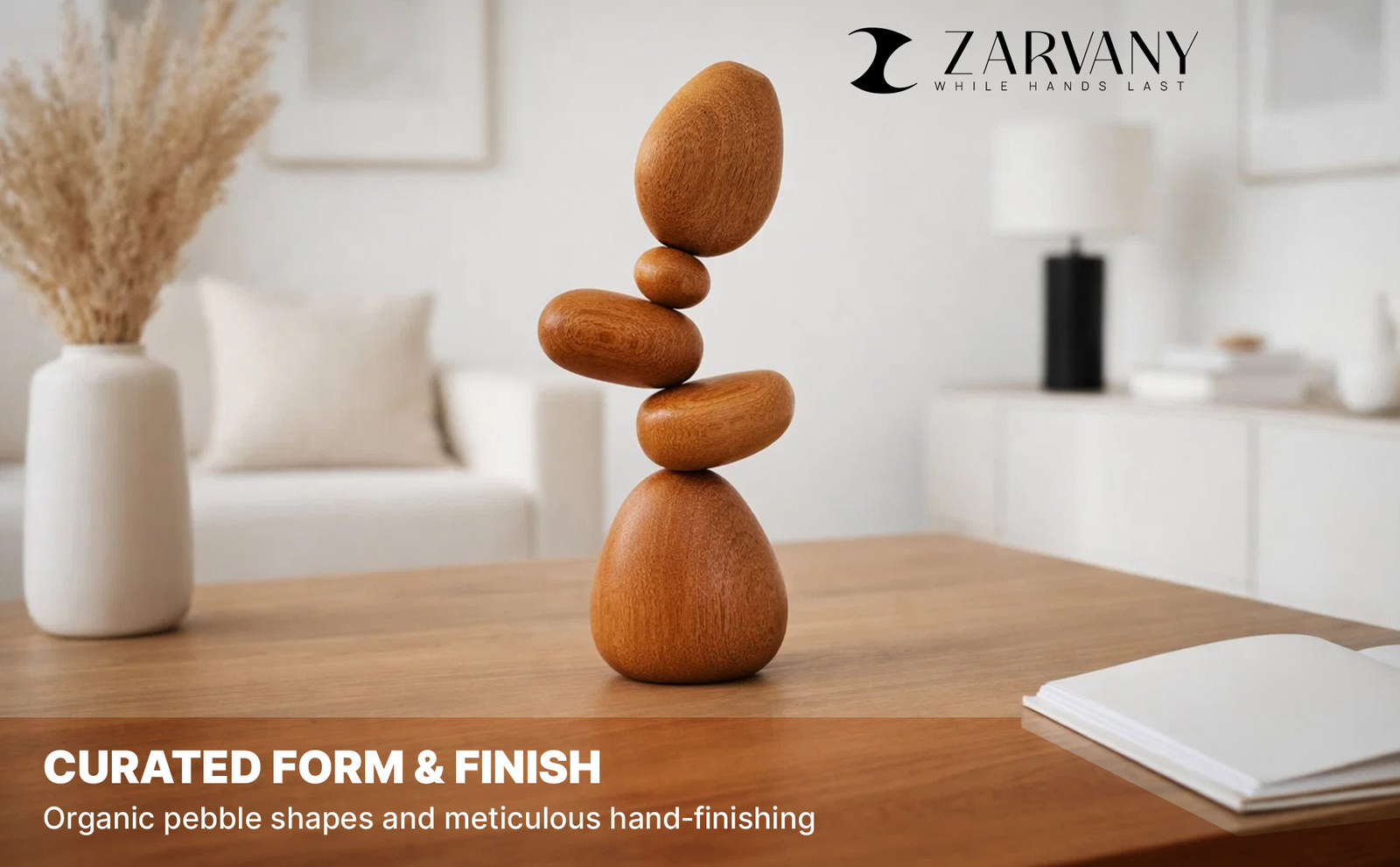 Stacked wooden stones on a table in a bright room with dried grass in a vase