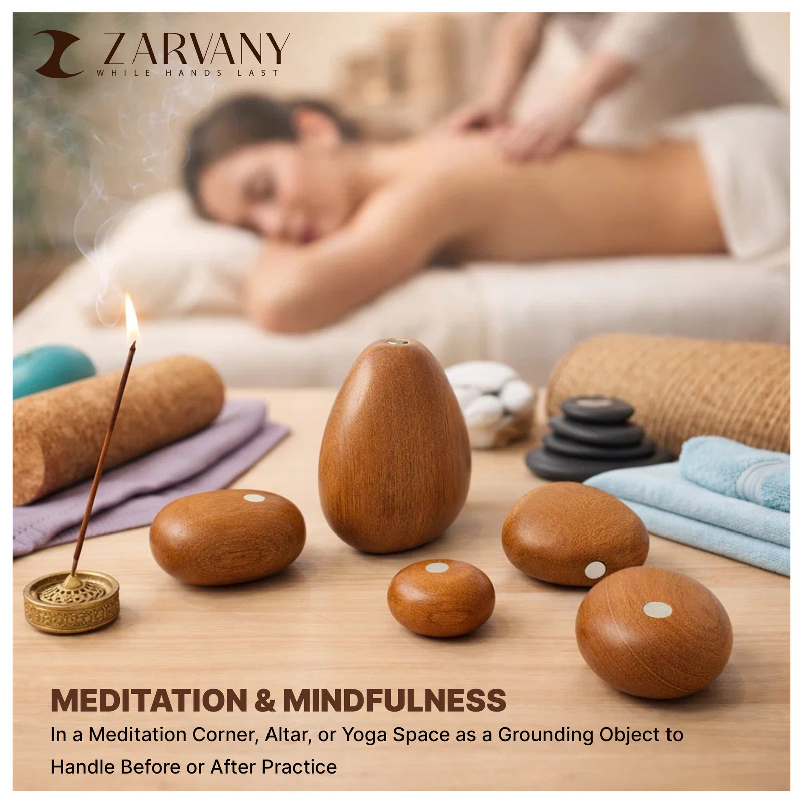 Wooden stones with incense and towels in front of a person on a massage table